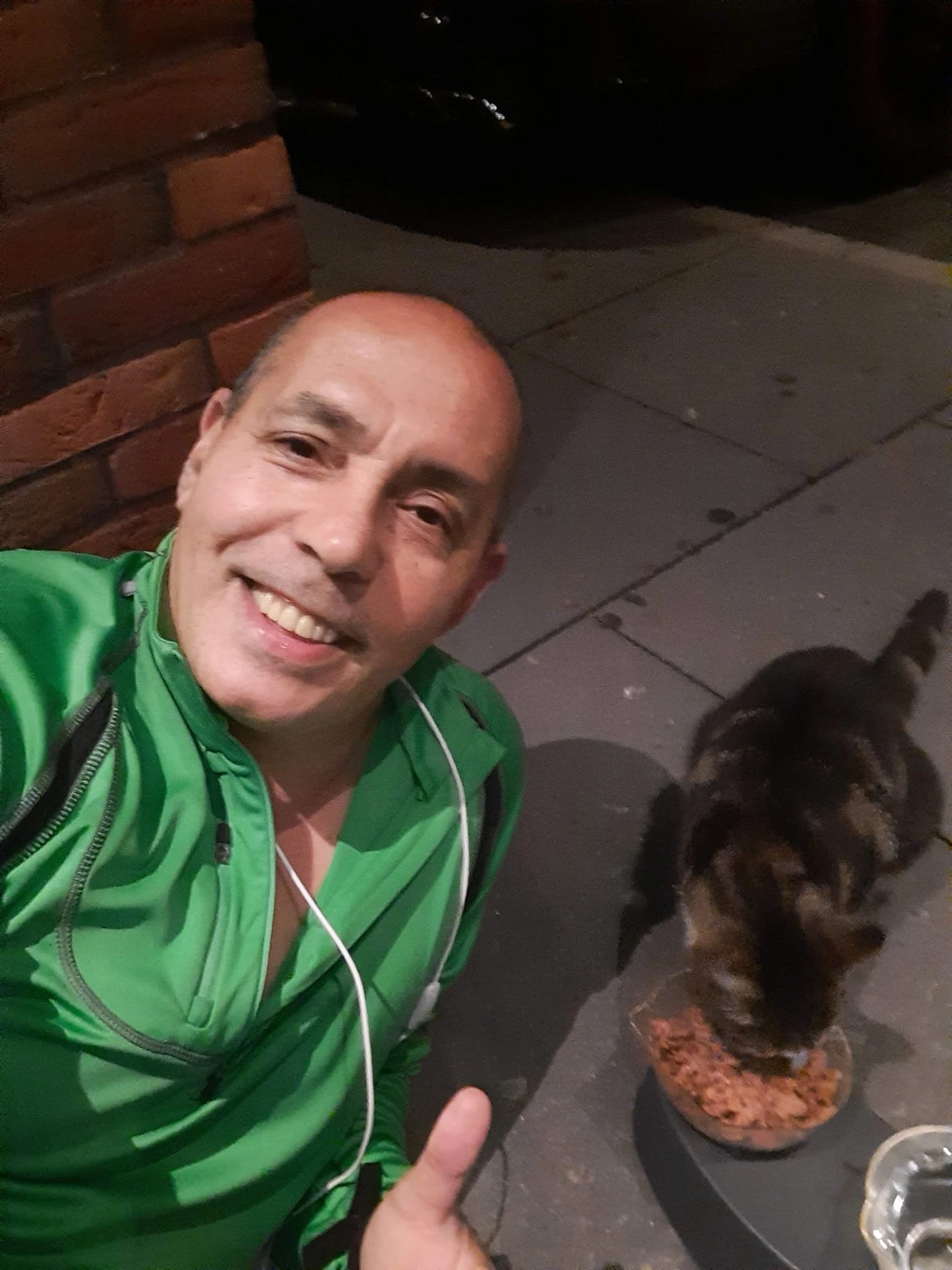 Man in groen jack glimlachend naar camera, mogelijk personeelslid of vrijwilliger