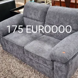 Grijze tweedehands stoelgroep met twee zitplaatsen op een vloerkleed in de kringloopwinkel