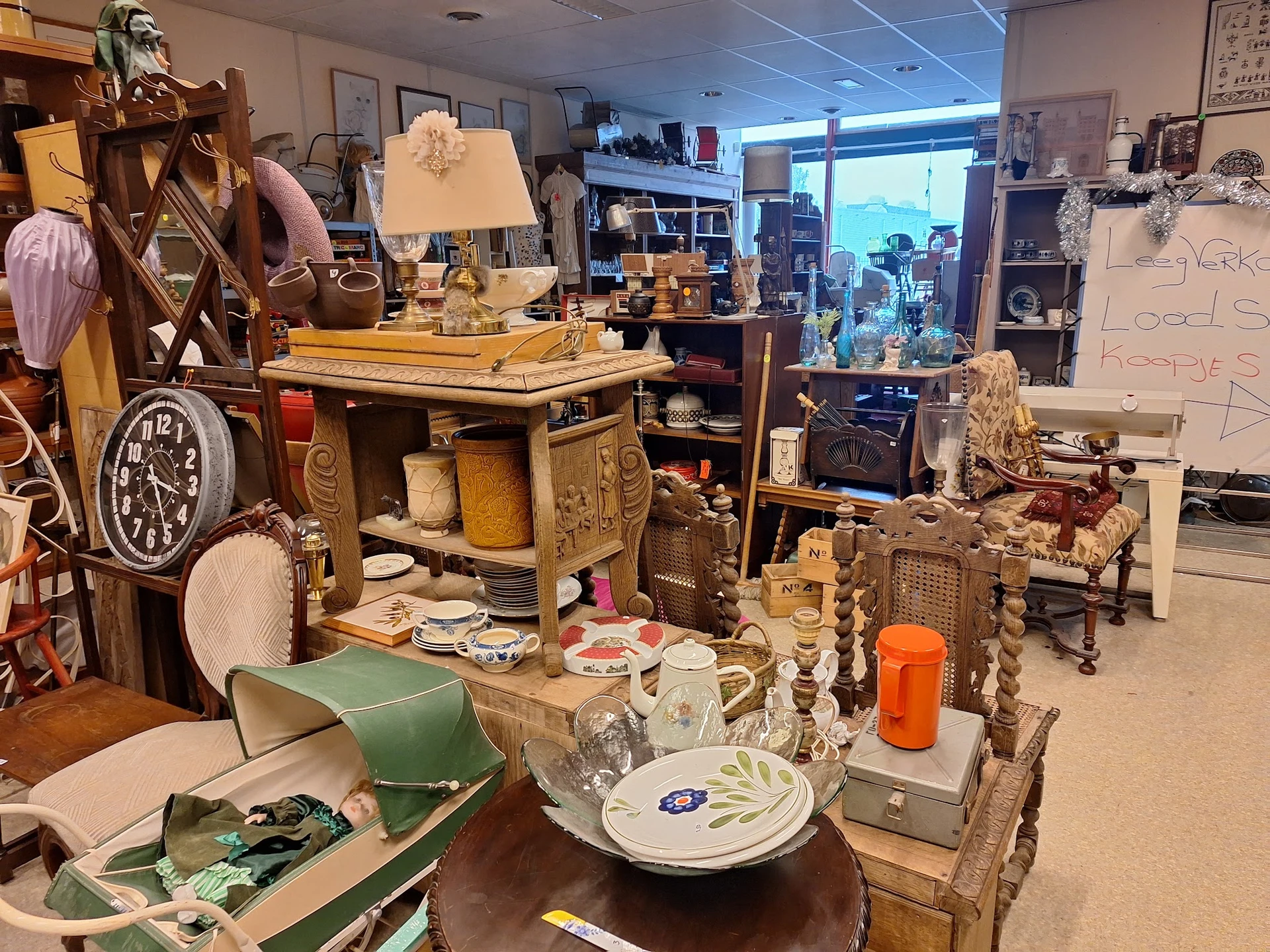 Winkelvloer met diverse tweedehands meubels, servies, lampen en decoratieartikelen uitgestald