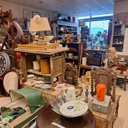 Winkelvloer met diverse tweedehands meubels, servies, lampen en decoratieartikelen uitgestald