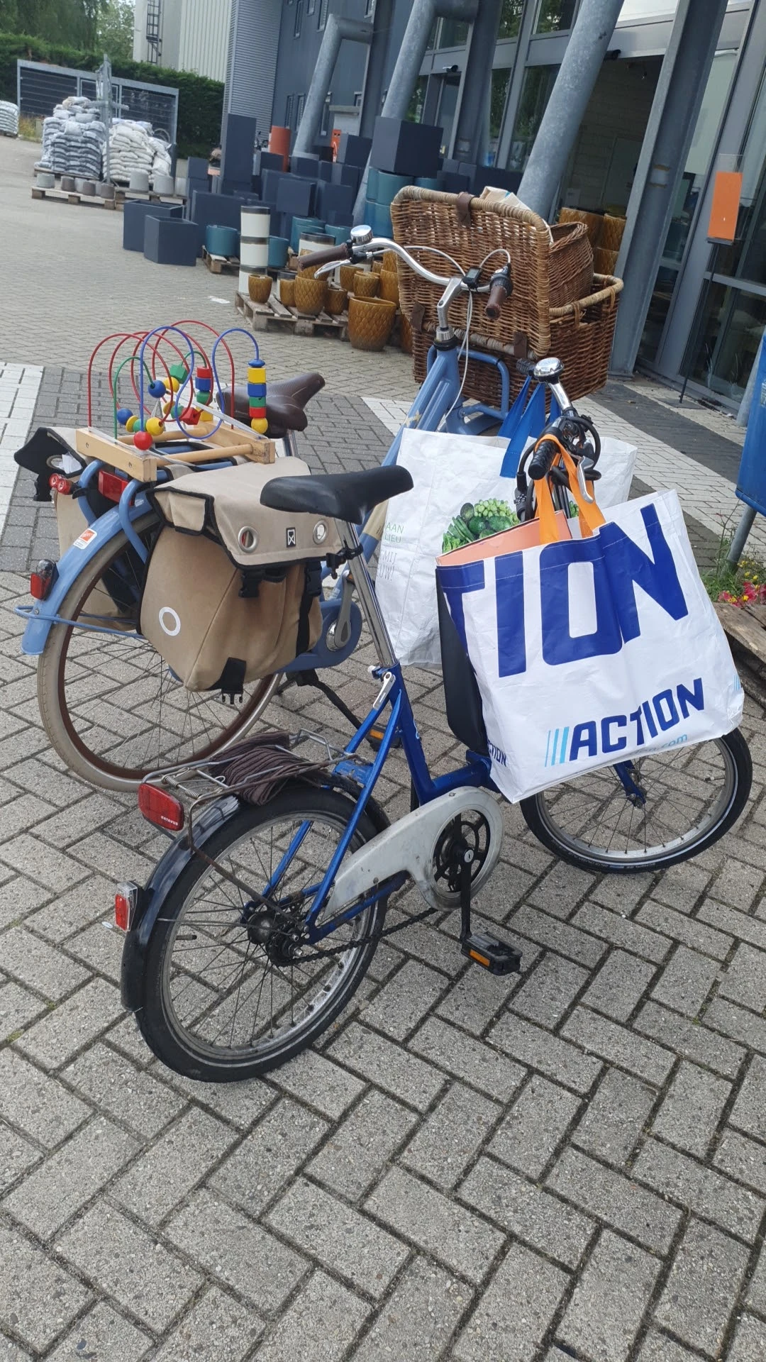 Twee tweewielers met tassen en een wit spandoek met 'TION' en 'ACTION' opgesteld buiten op straat