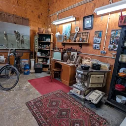 Winkelvloer met vintage huishoudapparatuur, meubels, televisies en decoratieartikelen op houten planken tegen houten wanden