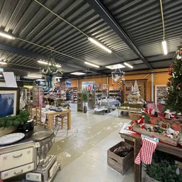 Binnenkant kringloopwinkel met verschillende afdelingen, kerstversiering en aangeboden spullen