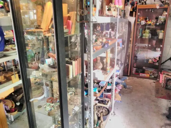 Glazen vitrines met verzamelobjecten en spullen in de winkel, zicht op meerdere afdelingen met displays