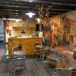 Winkelvloer met zittafel, bar en versierde wanden met bloemen en planten