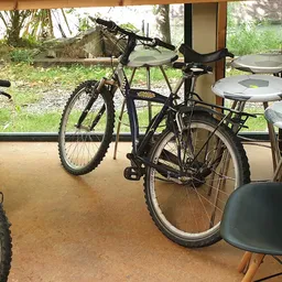 Fietsen en stoelen in een overdekt winkelgedeelte met glazen deuren naar buiten
