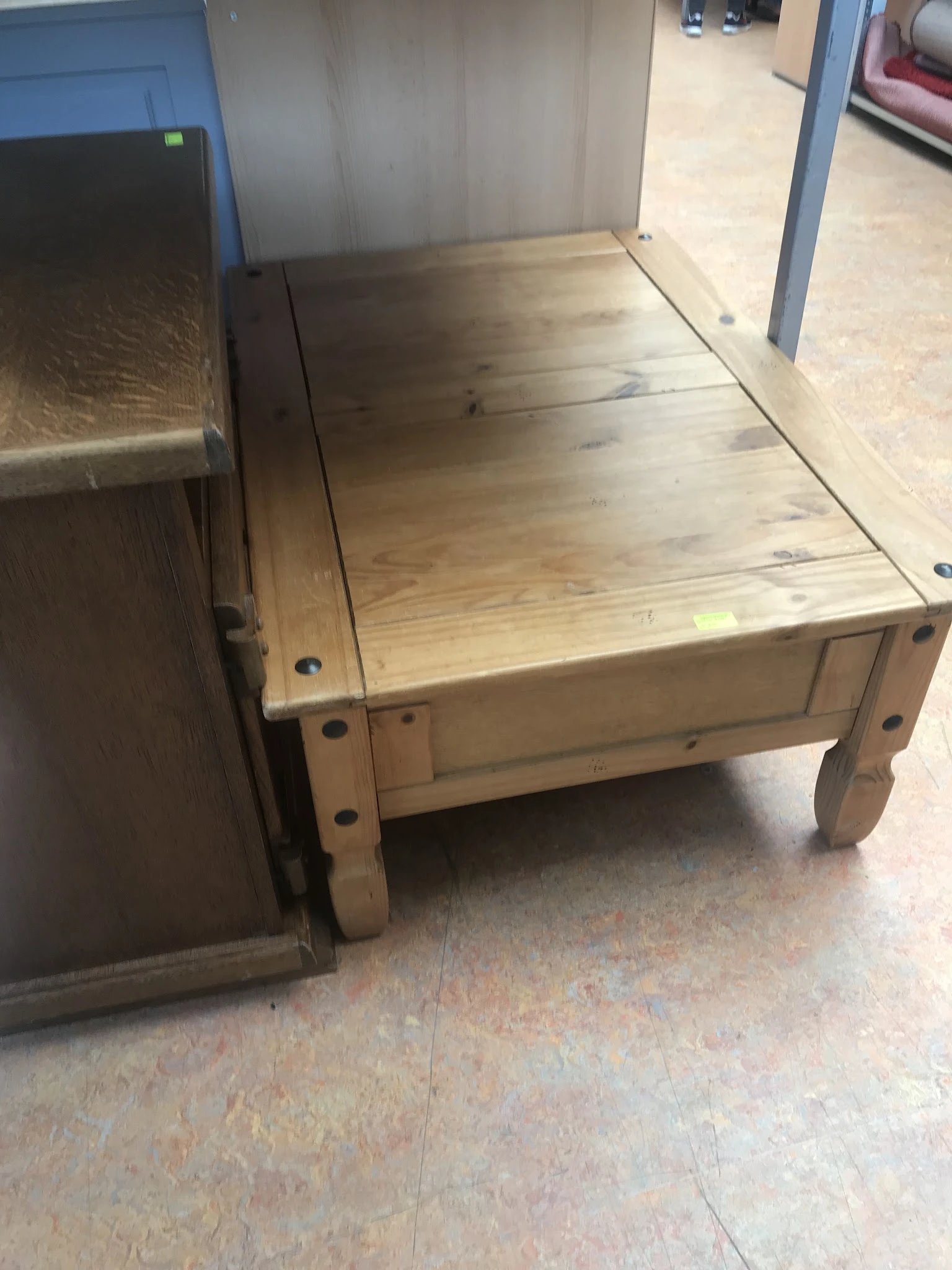 Houten tafel of werkbank met poten en donker blad, tegen muur en vloer