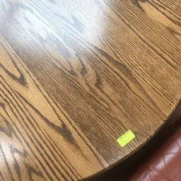 Houten tafelblad met geelgroen prijskaartje en schaduwpatroon van jaloeziën