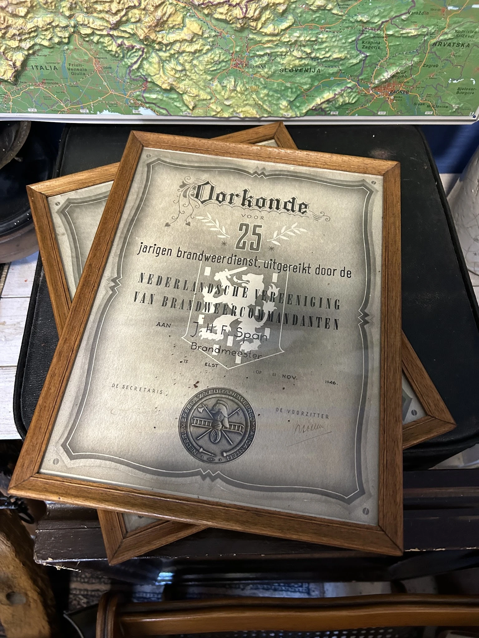 Ingelijste oorkonde uit 1925 voor 25 jaar brandweerdienst, uitgereikte door Nederlandse Brandweer Vereniging