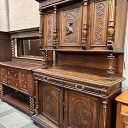 Antieke houten kast met ornamentale snijwerk en spiegeldeuren, in klassieke stijl