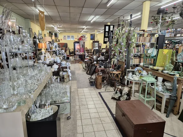 Winkelvloer van kringloopwinkel met diverse meubels, huishoudartikelen en decoraties uitgestald
