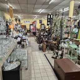 Winkelvloer van kringloopwinkel met diverse meubels, huishoudartikelen en decoraties uitgestald
