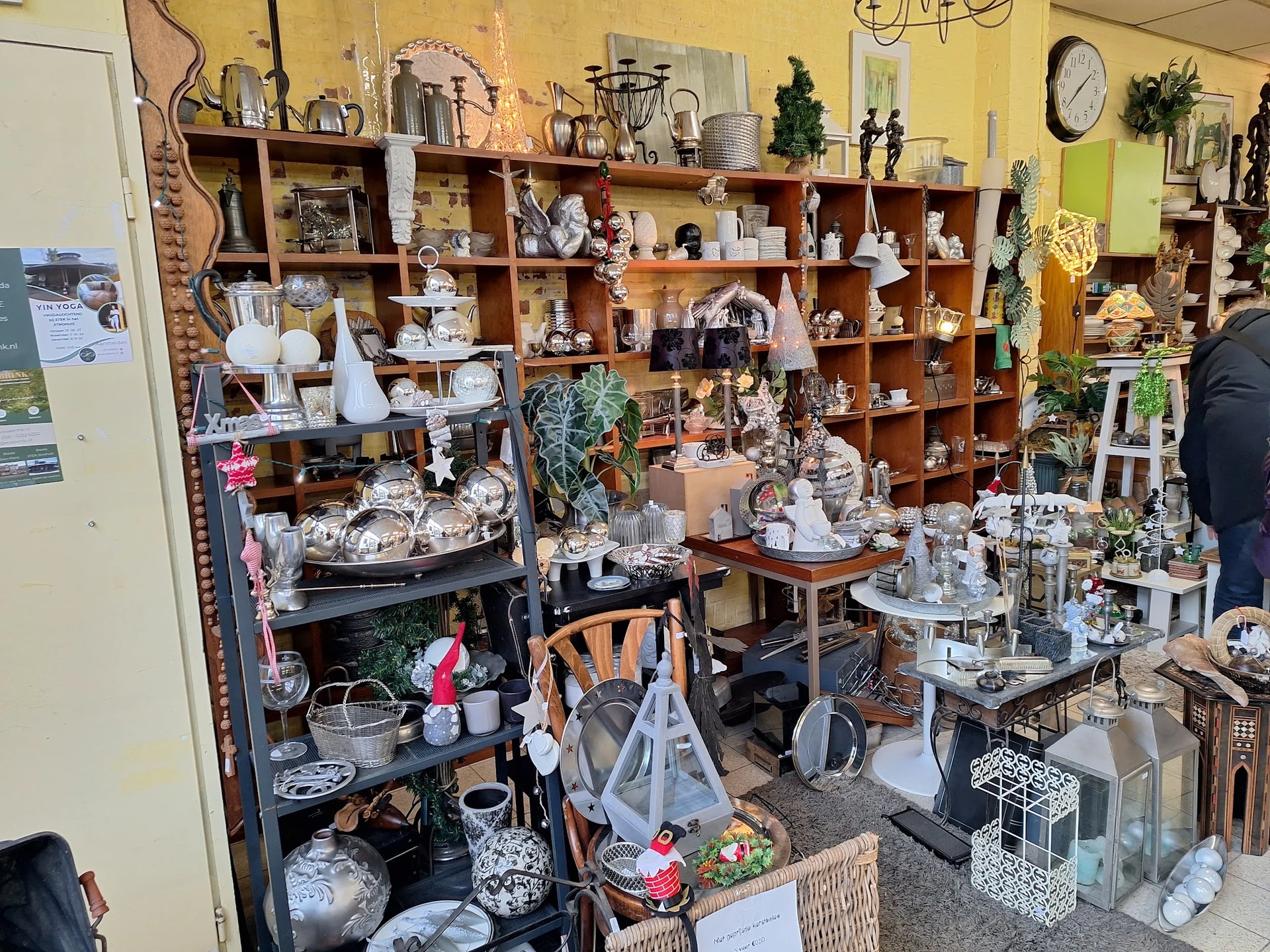 Winkelvloer met houten stellingen vol decoratieve huishoudartikelen, serviesgoed en woonaccessoires
