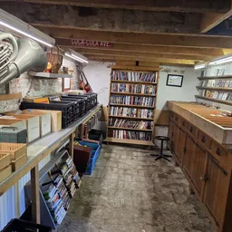 Winkelinterieur met boeken, platen en vintage items op stellingen en toonbanken