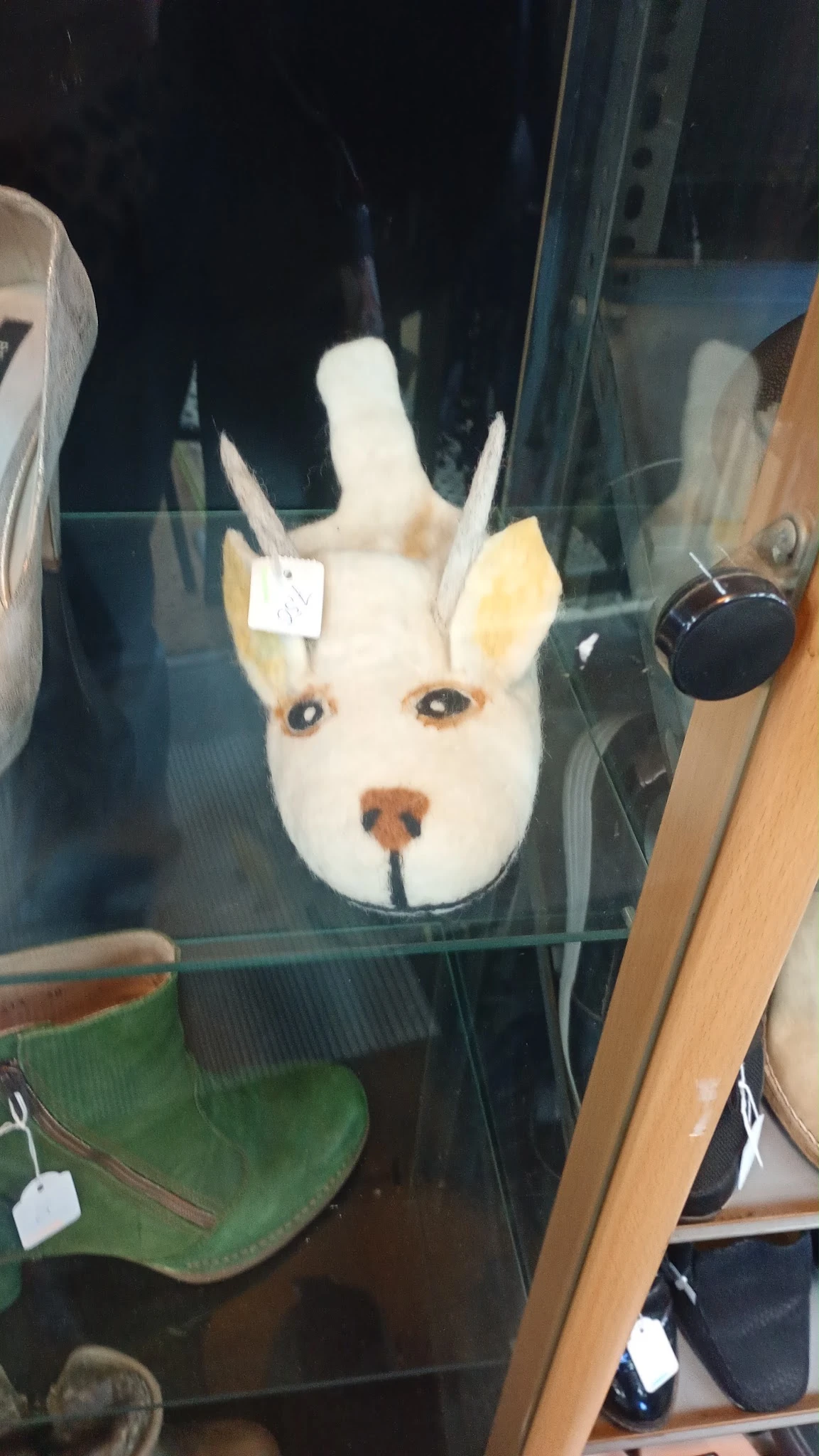 Close-up van een wit decoratief hondenhoofdje met gele oren en bruine neus