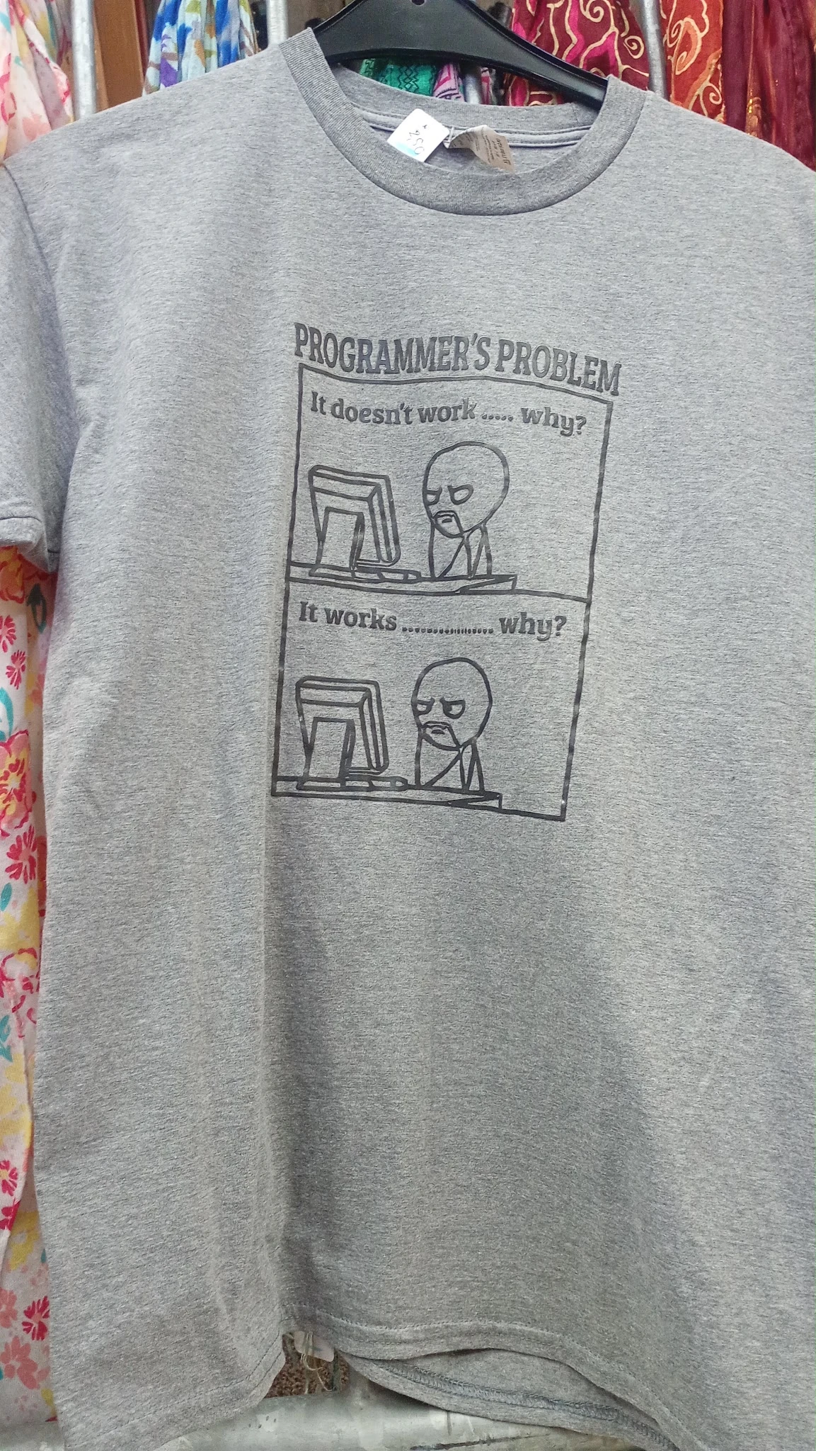 Grijze t-shirt met comic-strip print van een figuur achter een computer