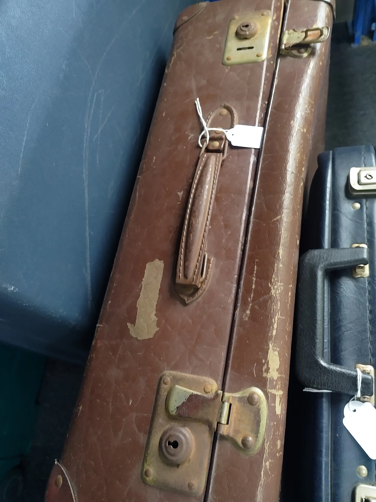 Close-up van een bruine vintage koffer met sluitingen en handvat
