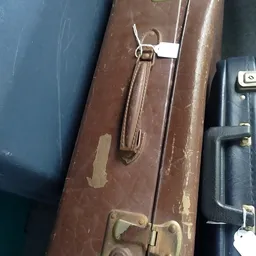 Close-up van een bruine vintage koffer met sluitingen en handvat