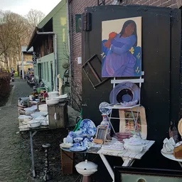 Uitgestalde tweedehands servies, borden en decoratieve items buiten een kringloopwinkel