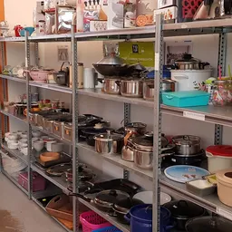 Metalen stellingen met kookgerei, pannen, potten en keukenaccessoires in verschillende maten en kleuren