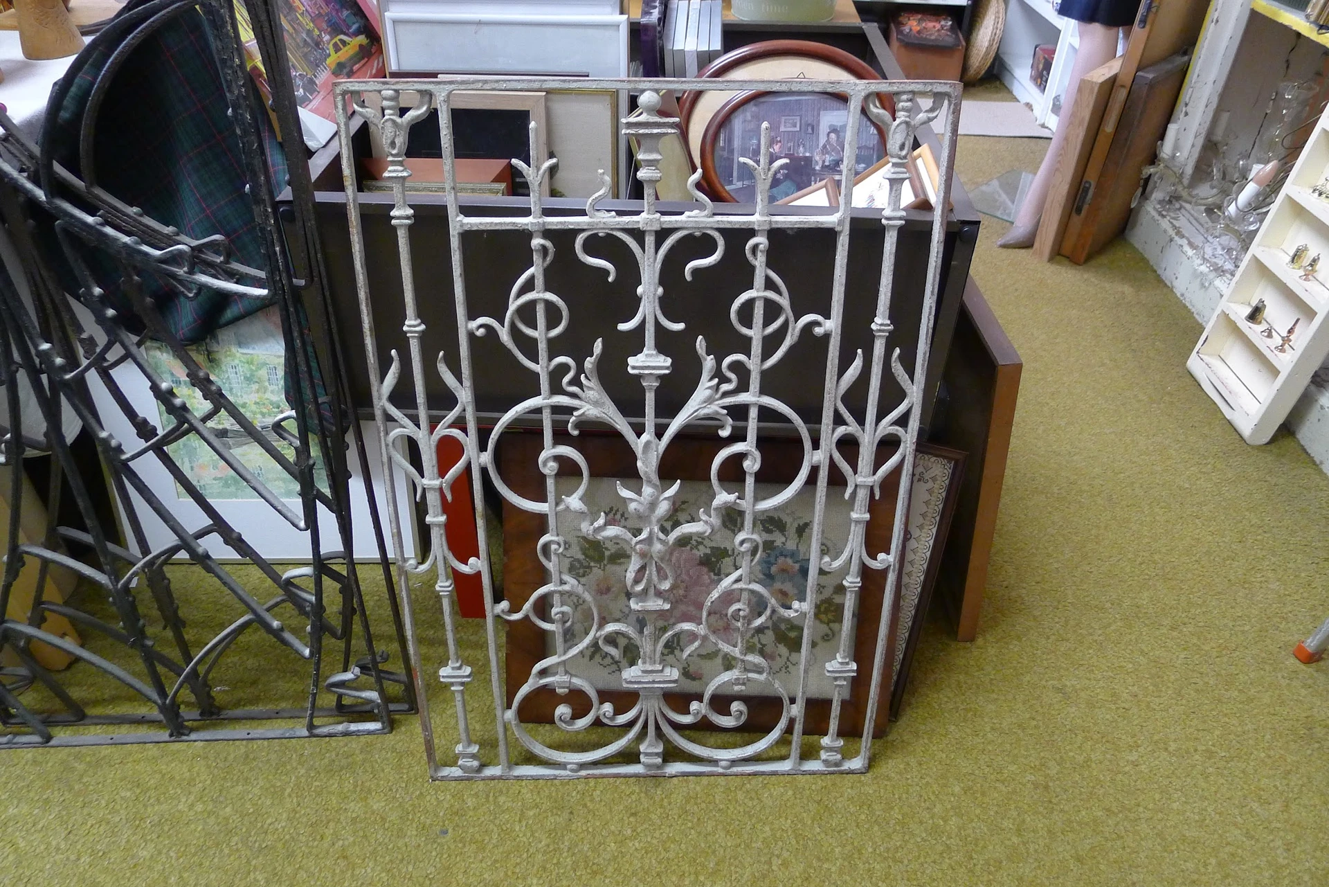 Decoratief ornamentaal hek of poort met wit metalen sierwerk, staande in de winkel