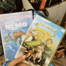 Twee dvd-boxen van Pixar-films: Finding Nemo en Shrek 2, tegen elkaar aangehouden