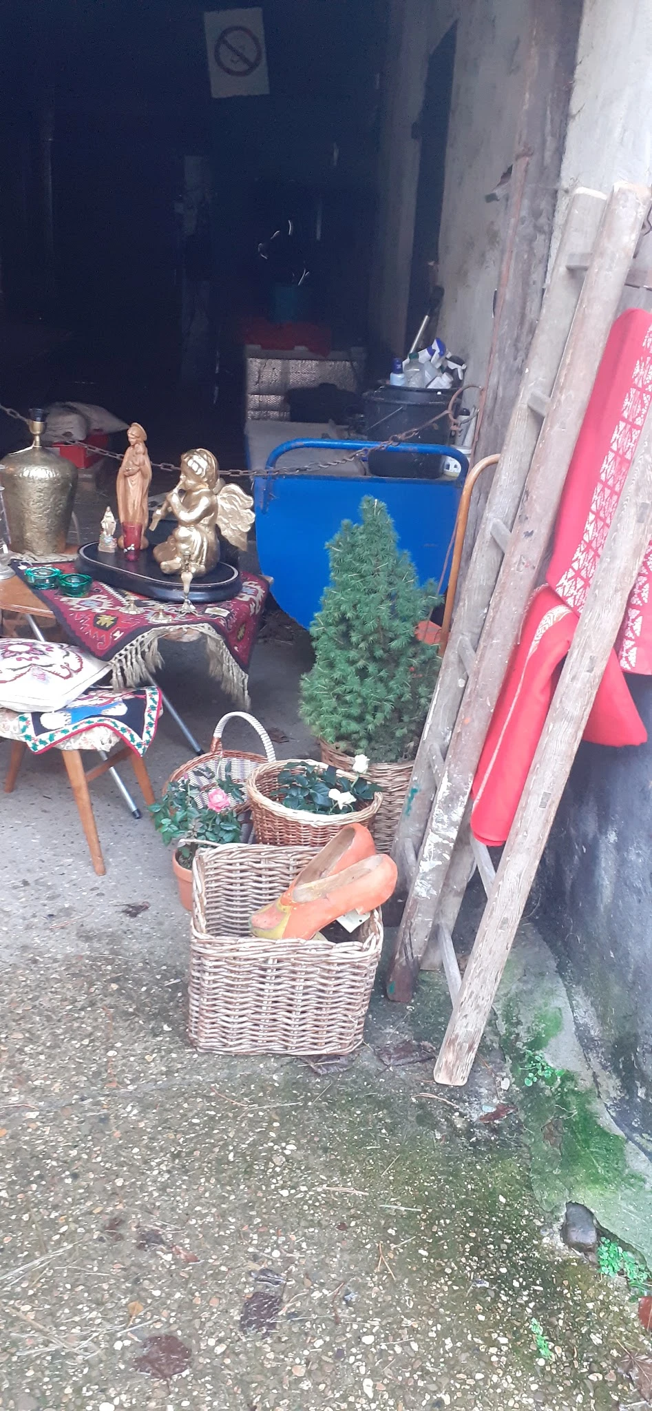 Uitgestalde spullen in een kringloopwinkel: wikkelmanden, decoratieve items, kleding en diversen
