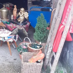Uitgestalde spullen in een kringloopwinkel: wikkelmanden, decoratieve items, kleding en diversen