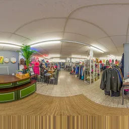 Panoramisch overzicht van kringloopwinkel met kledingrekken, toonbank en horeca-hoekje