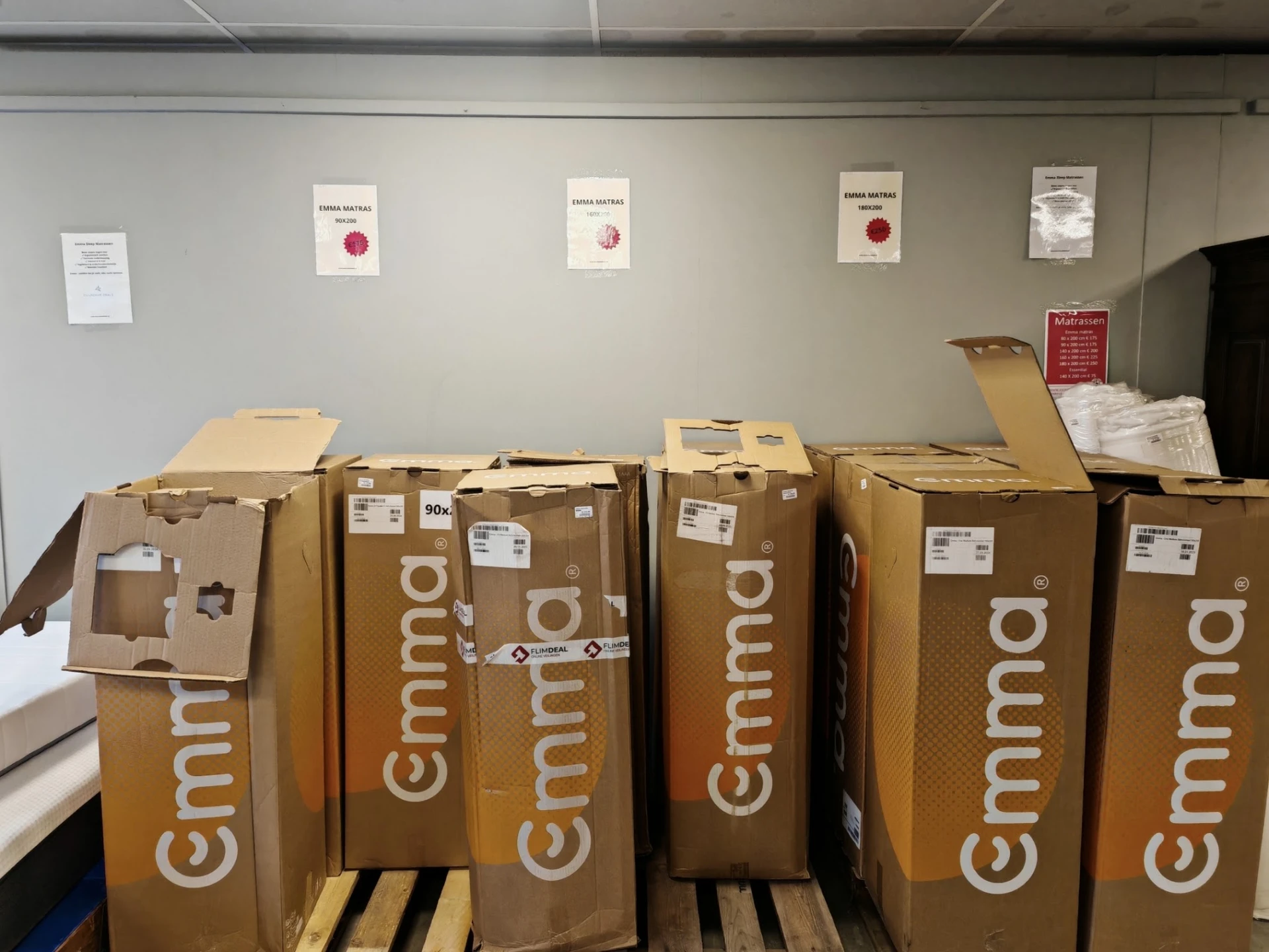 Rij met bruine Cimmo-dozen gestapeld in een opslagruimte, waarschijnlijk nieuwe voorraad voor de winkel
