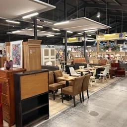 Winkelvloer met bruine stoelen, tafels en meubels in een kringloopwinkel