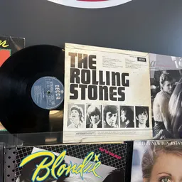 Verzameling tweedehands vinyl LP's en platen, waaronder The Rolling Stones, Blondie en andere klassieke albums op een schap