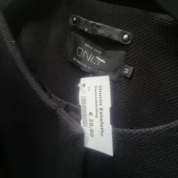 Zwart kledingstuk met prijskaartje van €20,00 en merklabel 'Estafette'