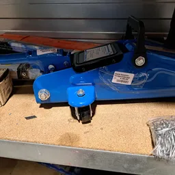 Blauwe sportuitrusting met accessoires op een werkbank, waaronder een hoofdband en trainingsapparatuur