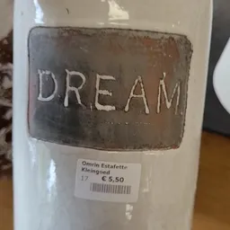 Wit keramiek item met het woord 'DREAM' gegraveerd, met prijssticker van 5,50 euro