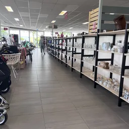 Winkelvloer met zwarte stellingen vol huishoudartikelen en decoratie langs de zijkant