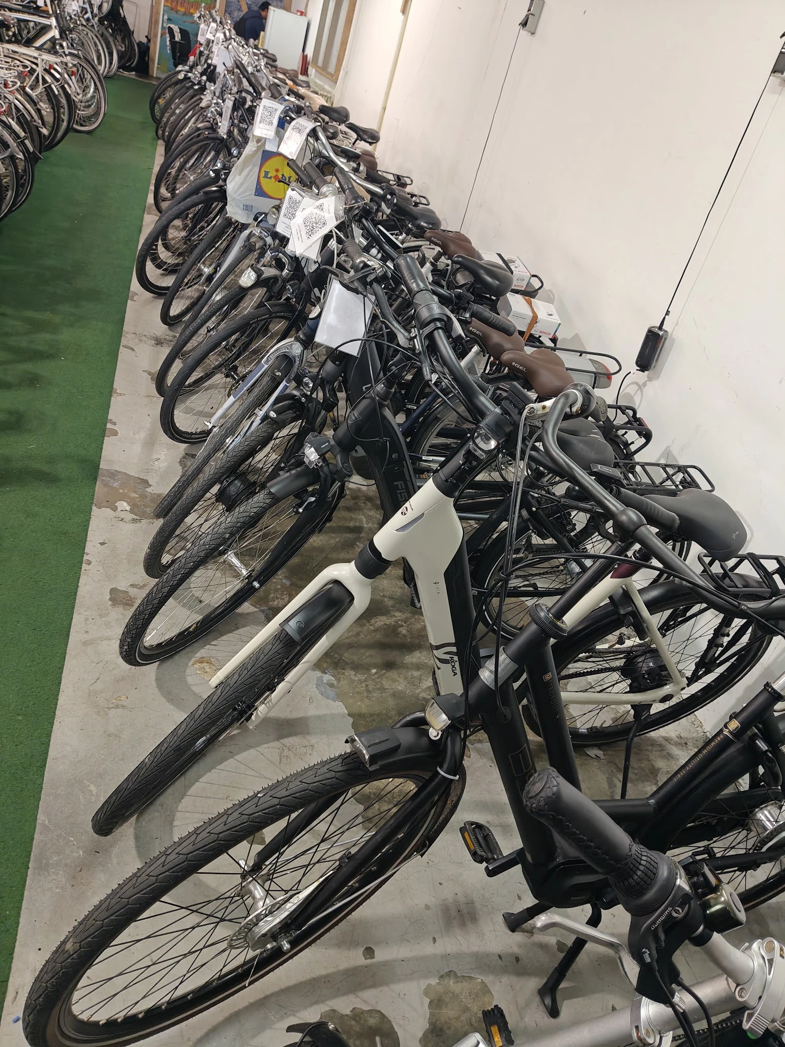 Rij van tweedehands fietsen in verschillende kleuren op een parkeerplaats
