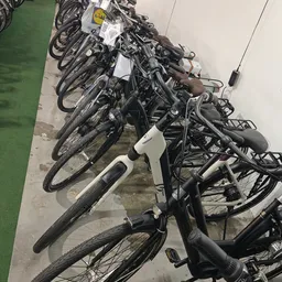Rij van tweedehands fietsen in verschillende kleuren op een parkeerplaats