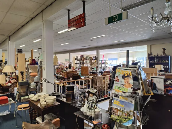 Winkelvloer met diverse meubels, lampen en huishoudspullen uitgestald in een kringloopwinkel
