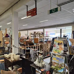 Winkelvloer met diverse meubels, lampen en huishoudspullen uitgestald in een kringloopwinkel