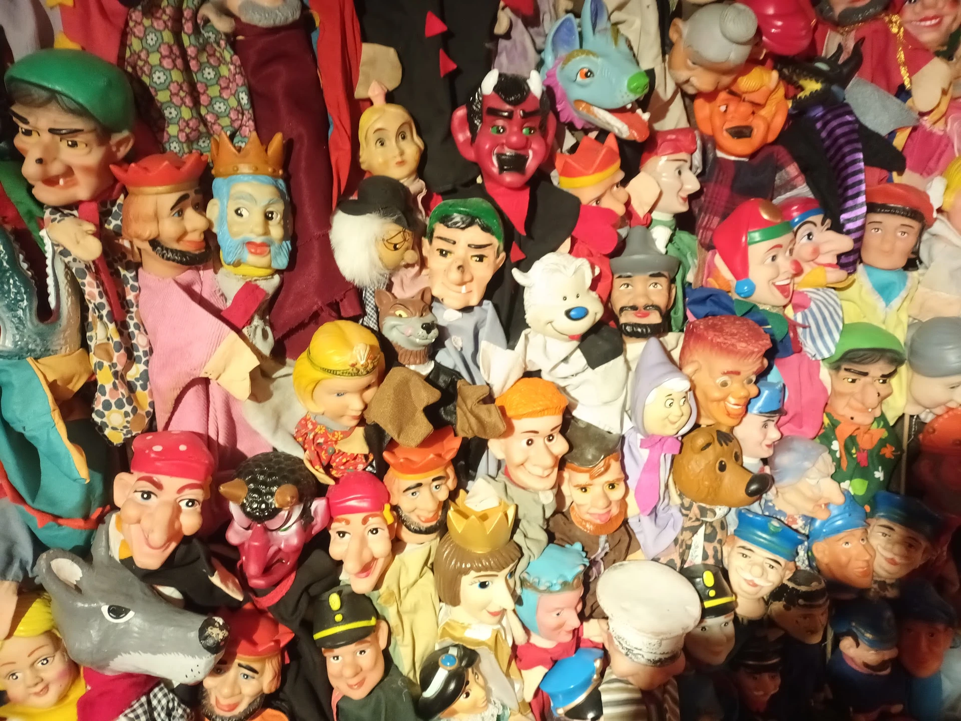 Verzameling vintage speelgoedpoppen en decoratiefiguren, dicht op elkaar gerangschikt