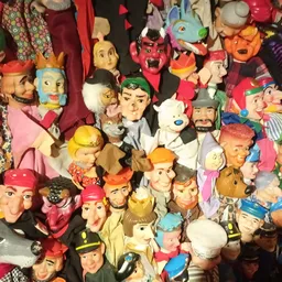 Verzameling vintage speelgoedpoppen en decoratiefiguren, dicht op elkaar gerangschikt