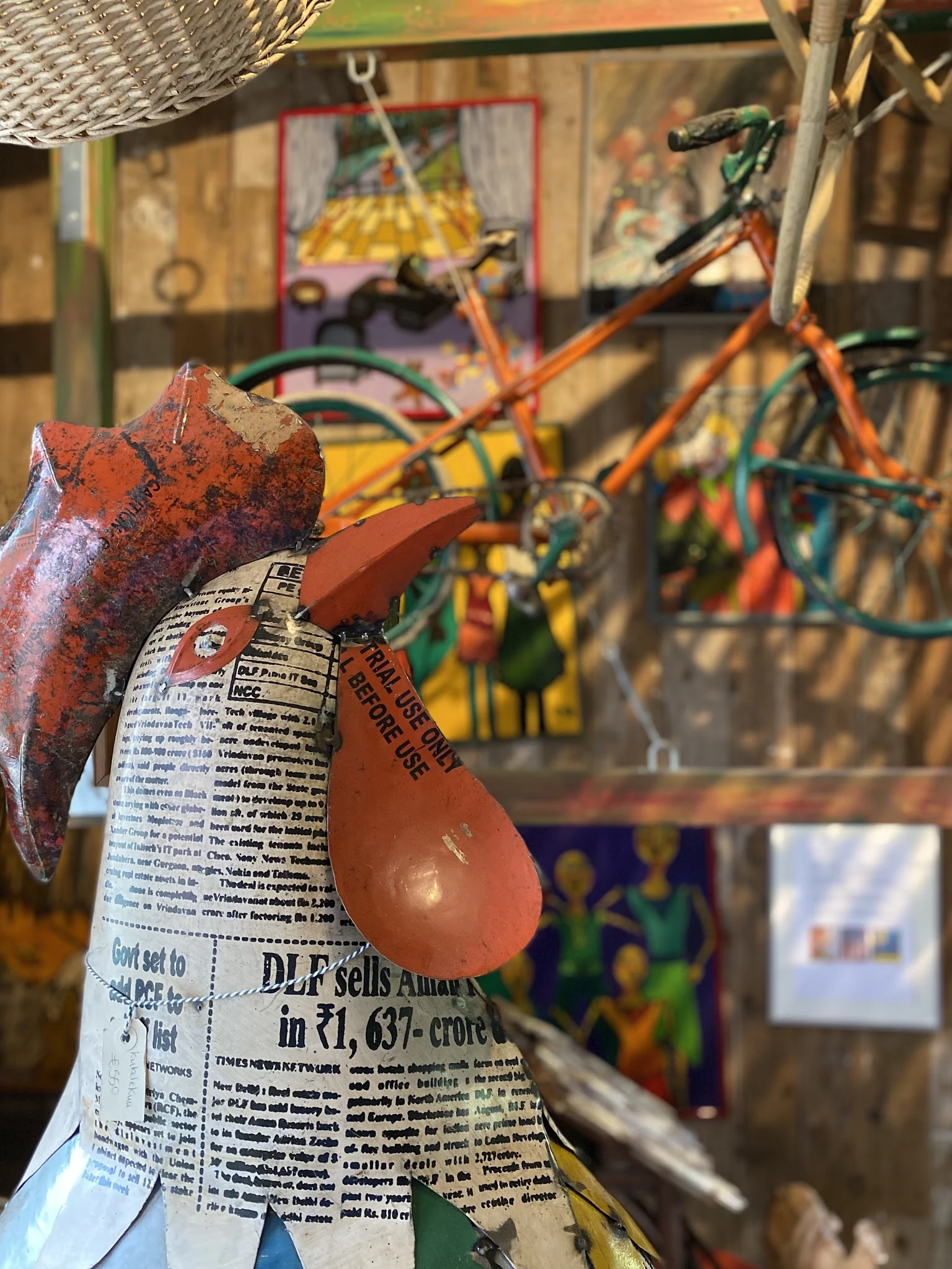 Close-up van decoratieve rode peren van papier-maché of karton met krantenprint, tegen achtergrond met fietsen en kunst