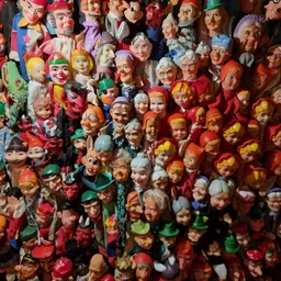 Grote verzameling kleurrijke vintage poppen en speelgoedhoofden op elkaar gestapeld