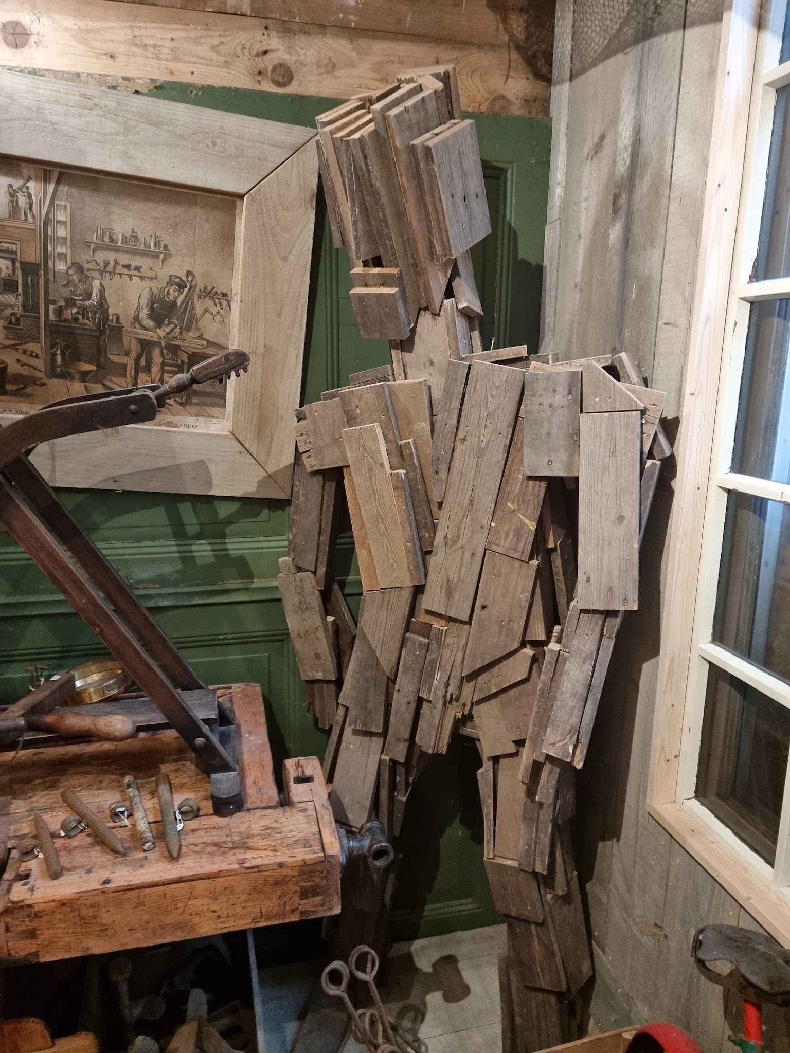 Verzameling oude houten planken en houtsnippers tegen muur, mogelijk bouwmaterialen of decorstukken