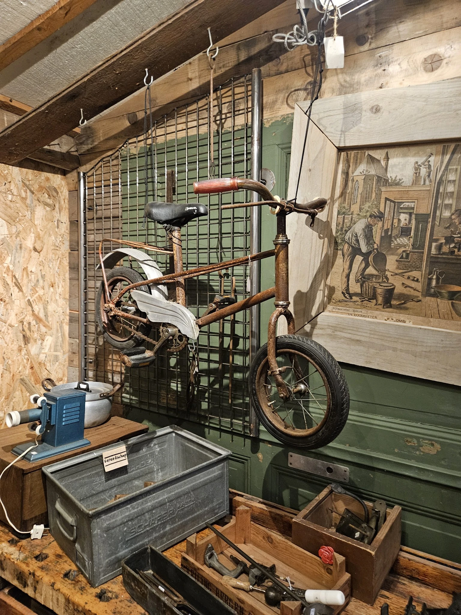 Vintage kinderfiets met witte banden tegen groene stellage in winkelinterieur