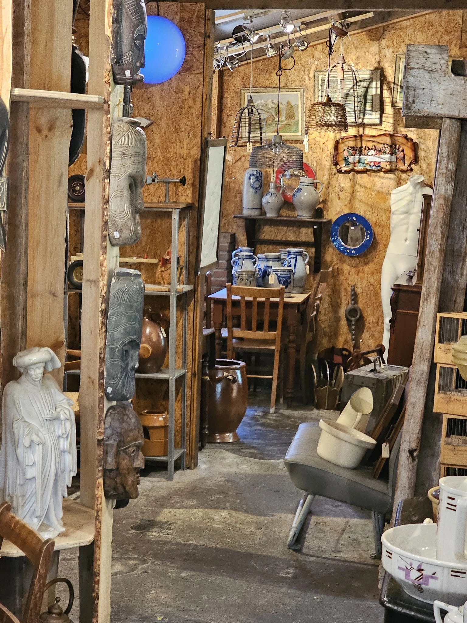 Winkelvloer met verzameling vintage spullen, decoraties en meubels tegen houten wanden