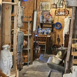 Winkelvloer met verzameling vintage spullen, decoraties en meubels tegen houten wanden