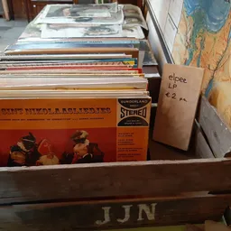 Houten krat met vinyl LP's en platen, waaronder klassieke albumhoezen in oranje en bruin