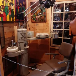 Vintage winkelinterieur met houten wanden, vintage apparaten op tafel, bruine stoel en wandkasten met spullen